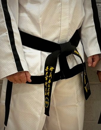 Close-up of a VI Degree black belt tied on a Taekwon-Do dobok